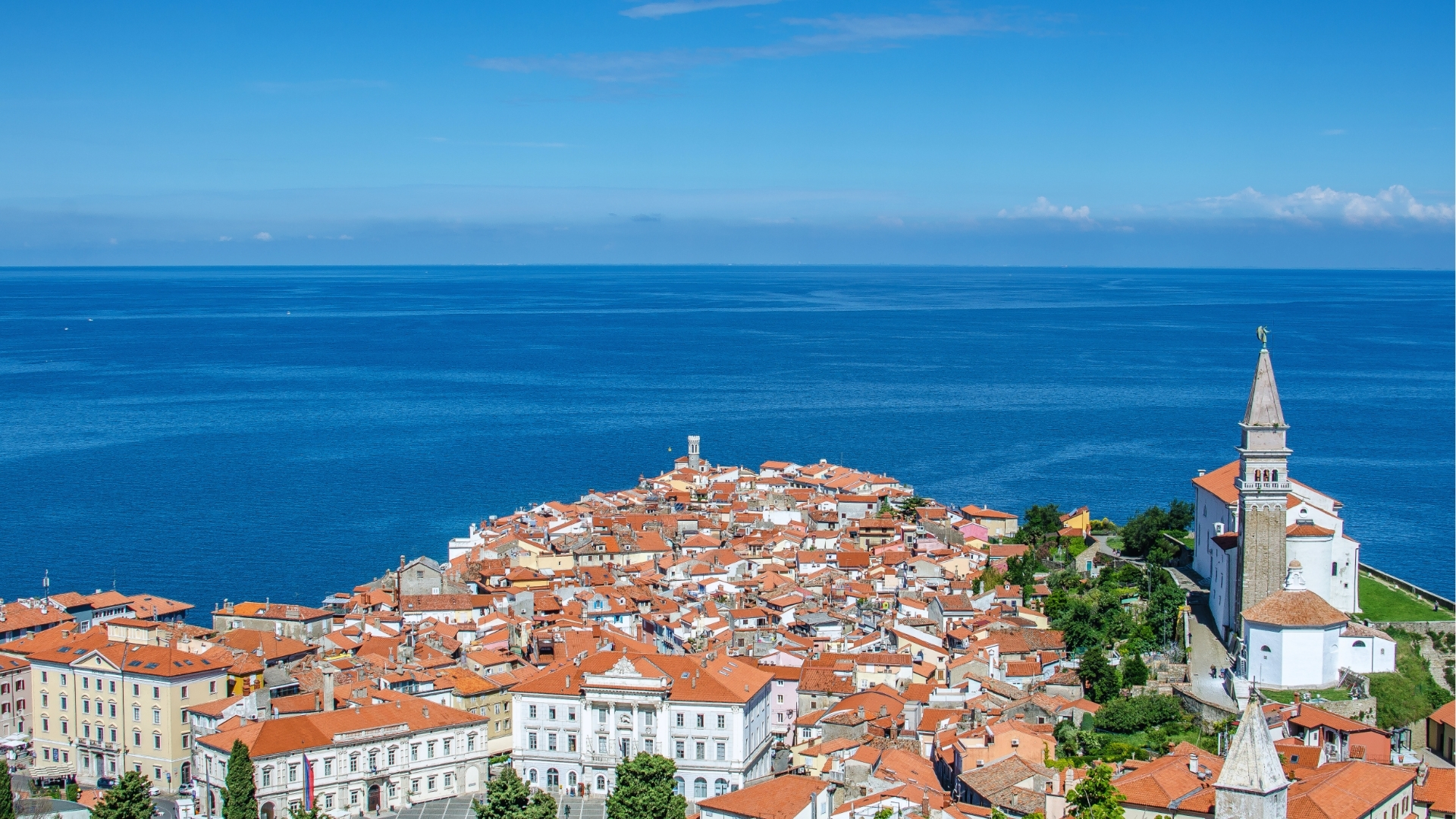 A panoramic view of the city of Roten, showcasing its skyline and surrounding landscape under a clear blue sky.