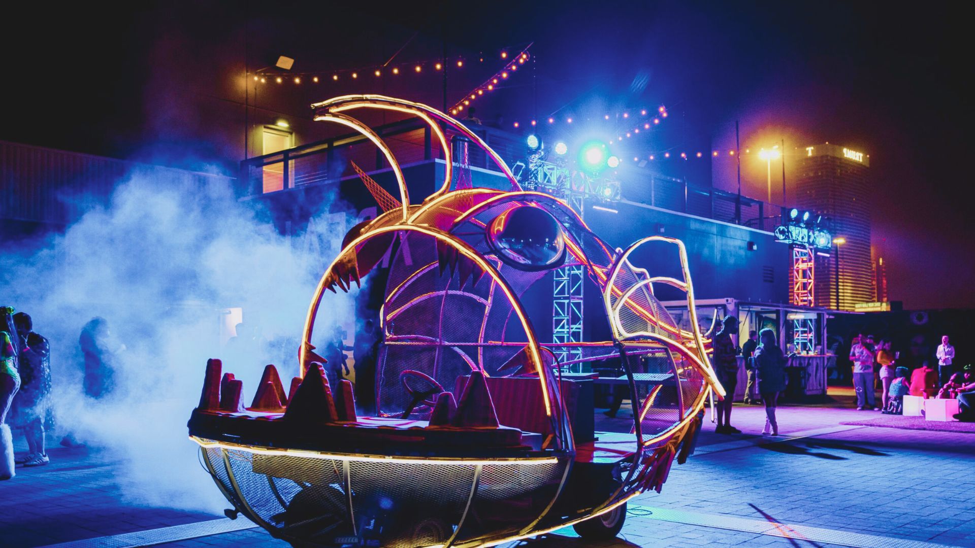A boat illuminated with lights, emitting smoke, creating a dramatic scene on the water at night.