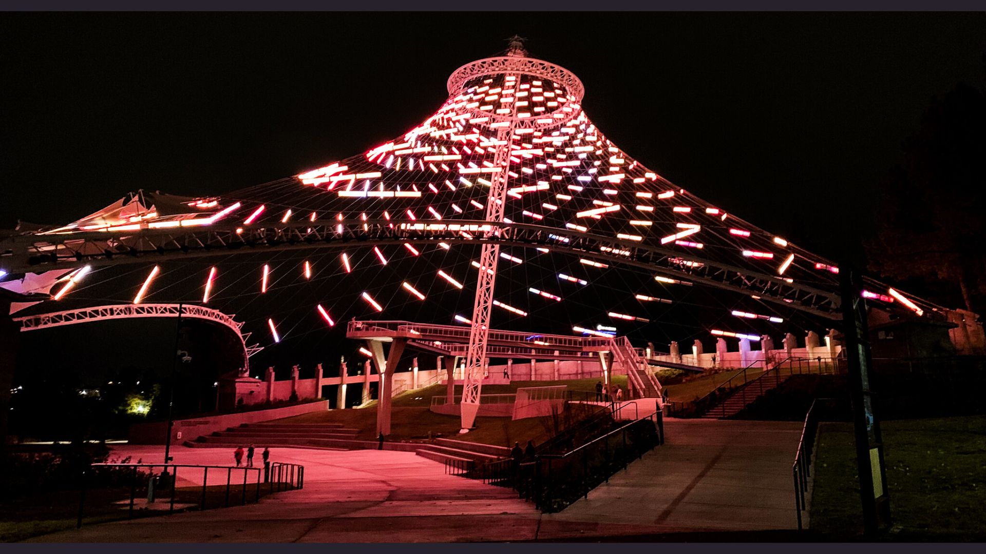 A large illuminated structure with multiple lights shining brightly against the night sky.
