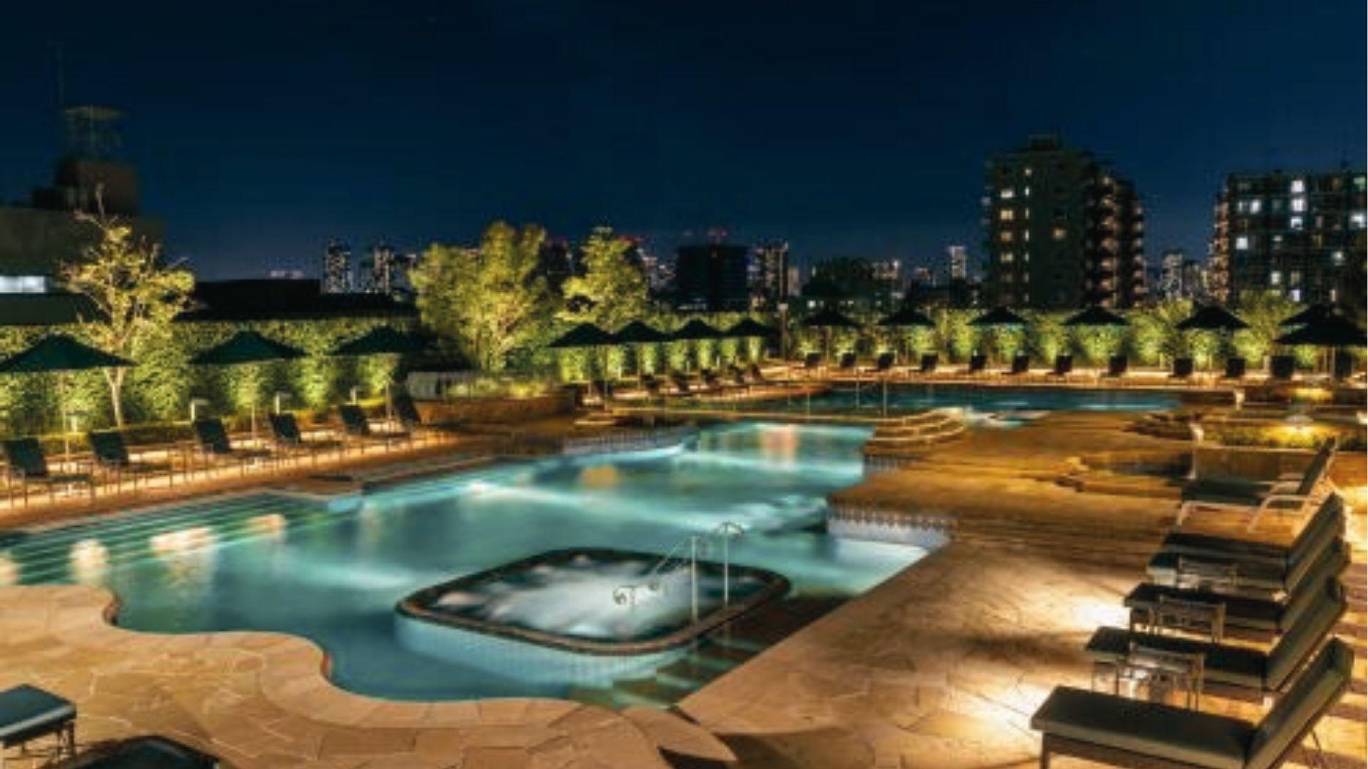 Rooftop pool and hot tub glow under city lights at night. Luxe December staycation in Tokyo, Japan.