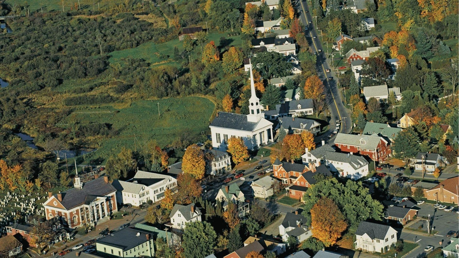 Aerial view of New England town with white church steeple. Classic December postcard winter vibes.