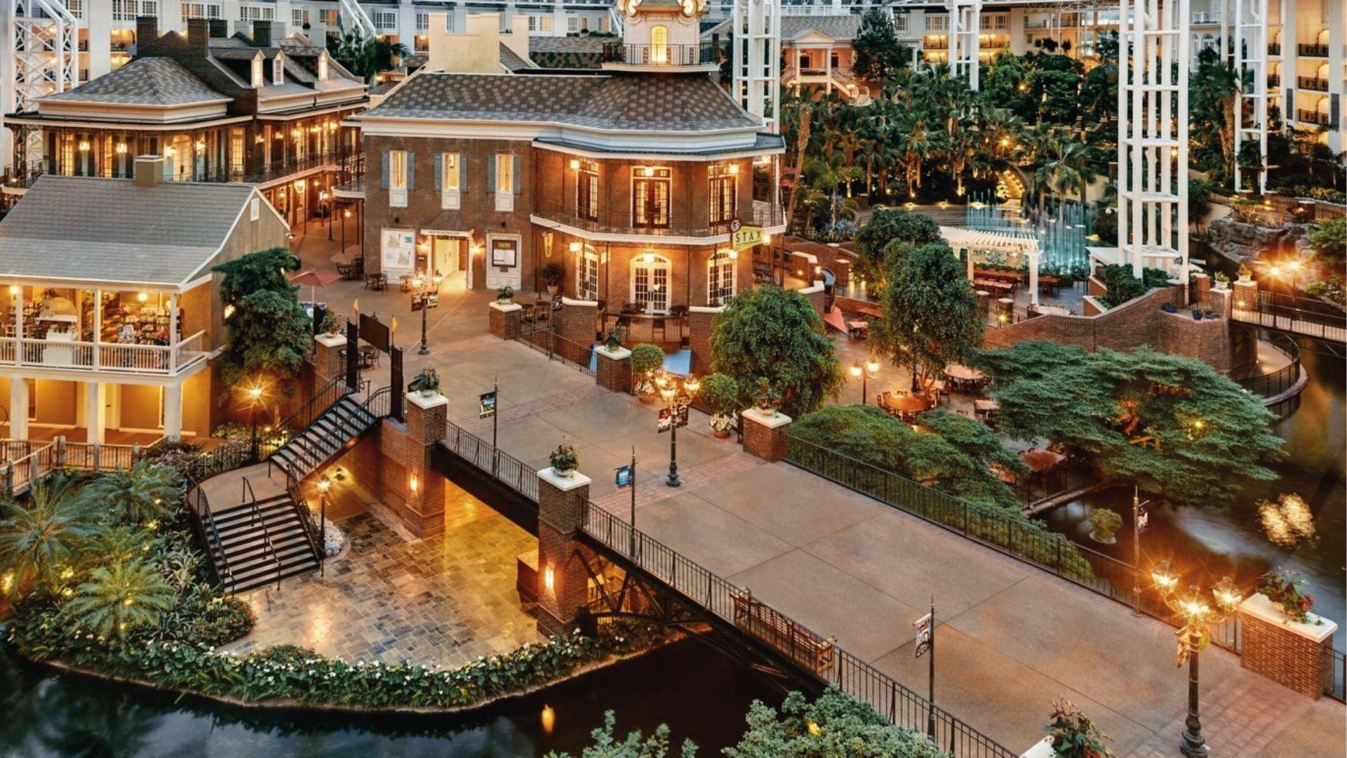 The indoor resort village glows with lights, canals, and palm trees. Warm December escapes under glass.