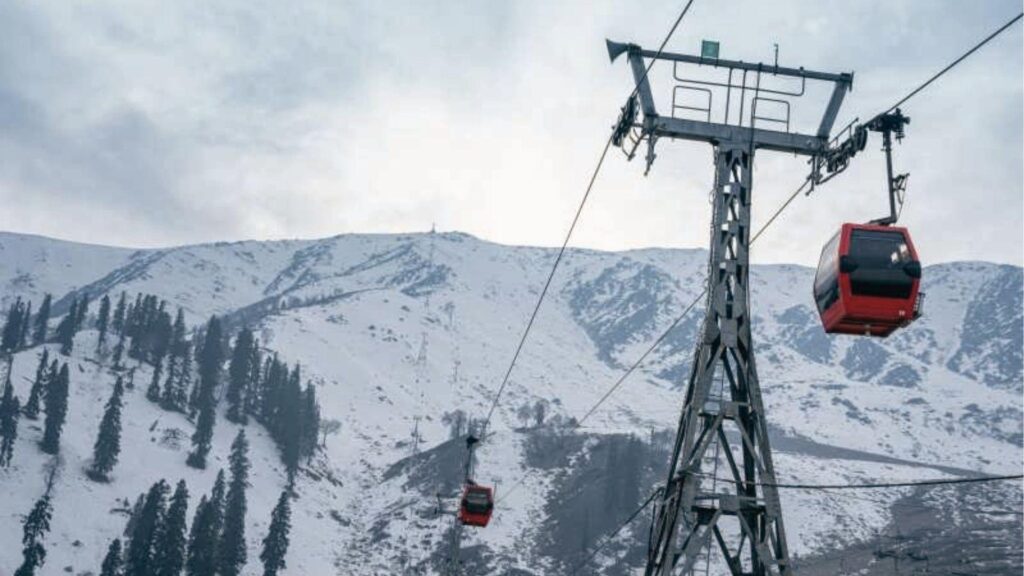 Red gondolas glide over snowy mountain slopes and pine trees. Top December spot for skiing.