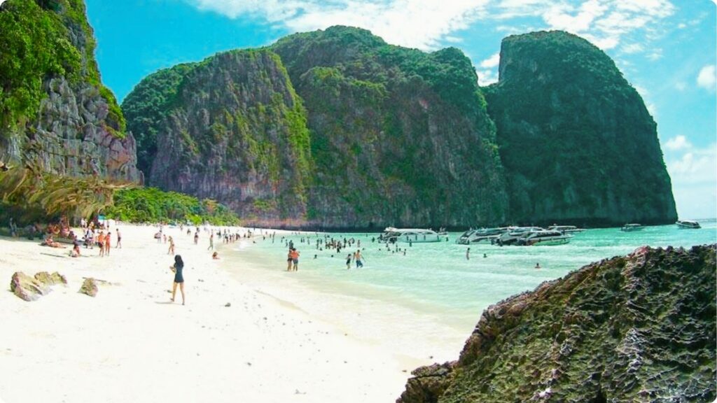 Crowds enjoy the white sand and crystal-clear water of a famous Thai beach cove.