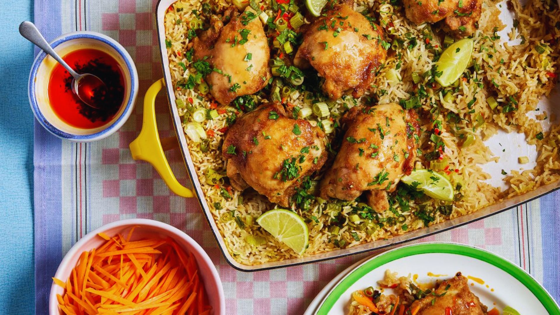 A plate of chicken and rice topped with carrots and a savory sauce, presented in a colorful arrangement.