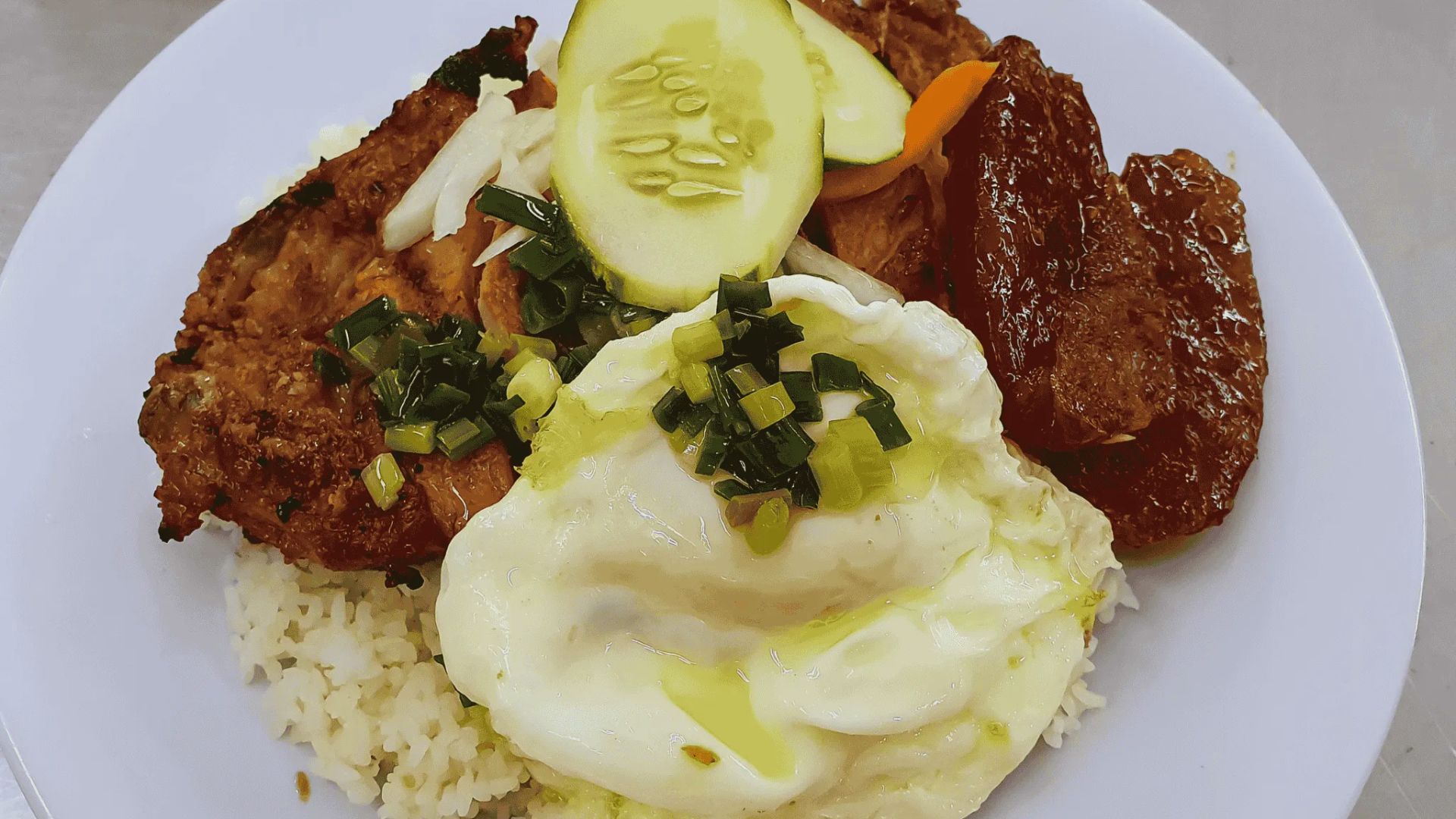 A plate featuring a serving of rice, tender meat, and a colorful assortment of vegetables.