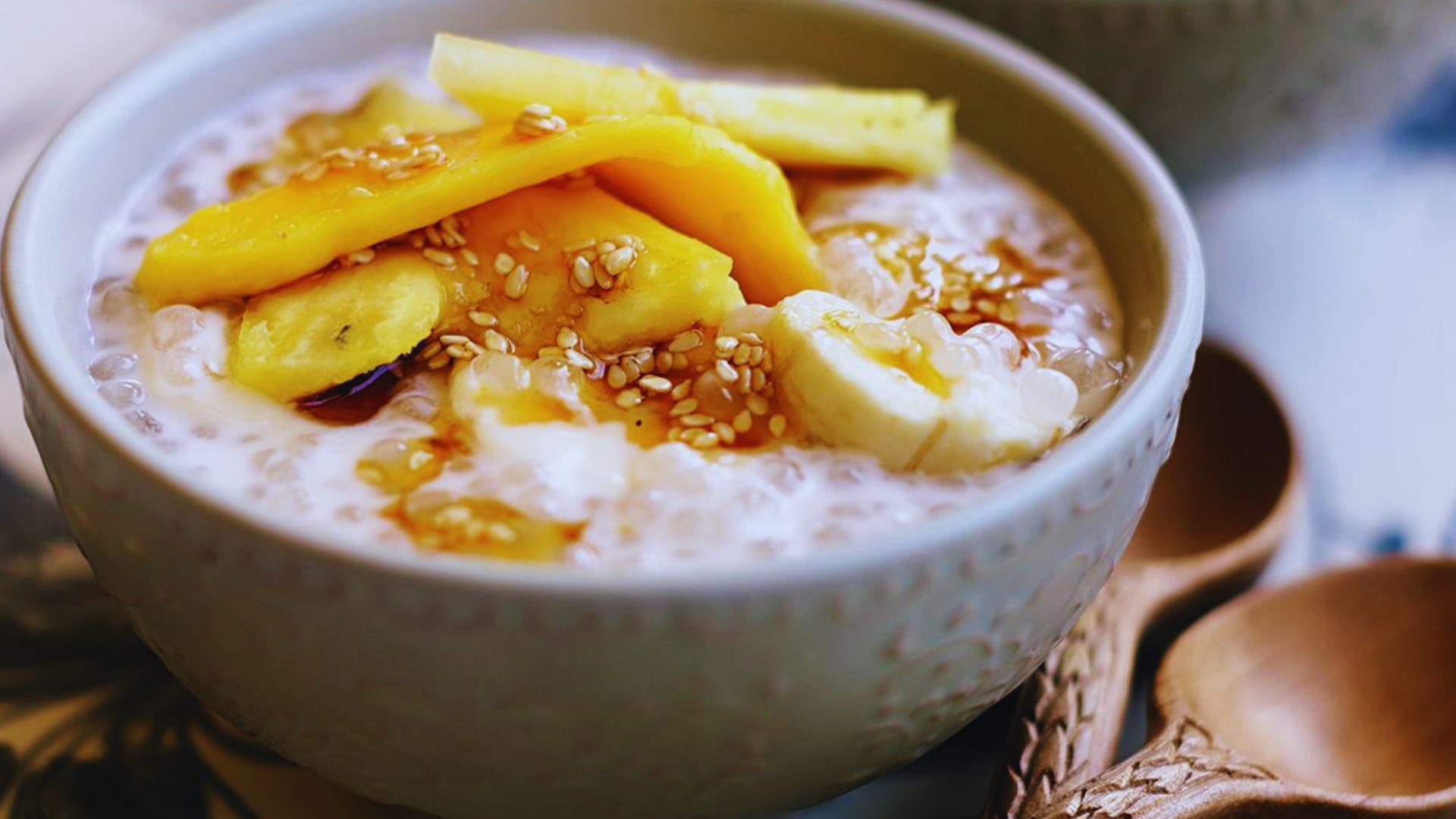 A bowl of oatmeal topped with sliced bananas and various colorful toppings, showcasing a healthy breakfast option.