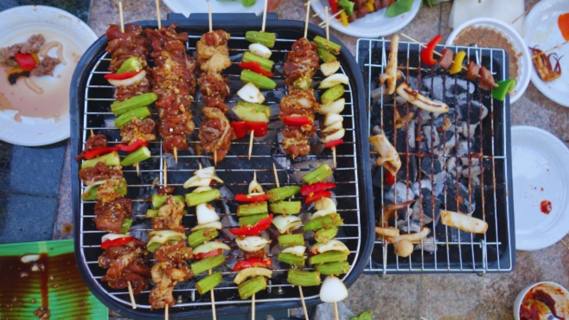 A grill featuring skewers loaded with assorted meats and colorful vegetables, ready for cooking.