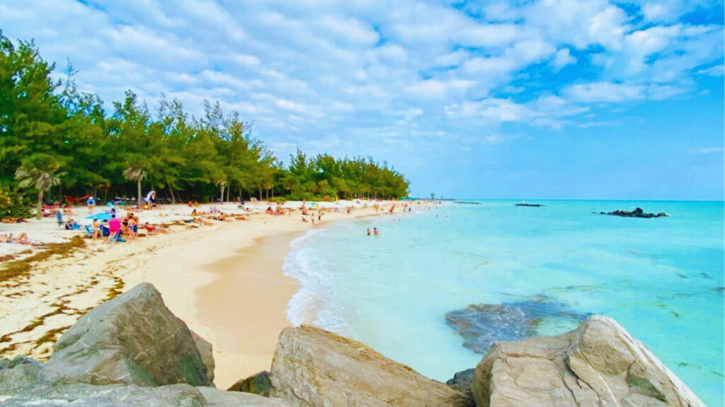 Fort Zachary Taylor Historic State Park beach with turquoise water, rocks, swimmers, and trees along Key West shoreline