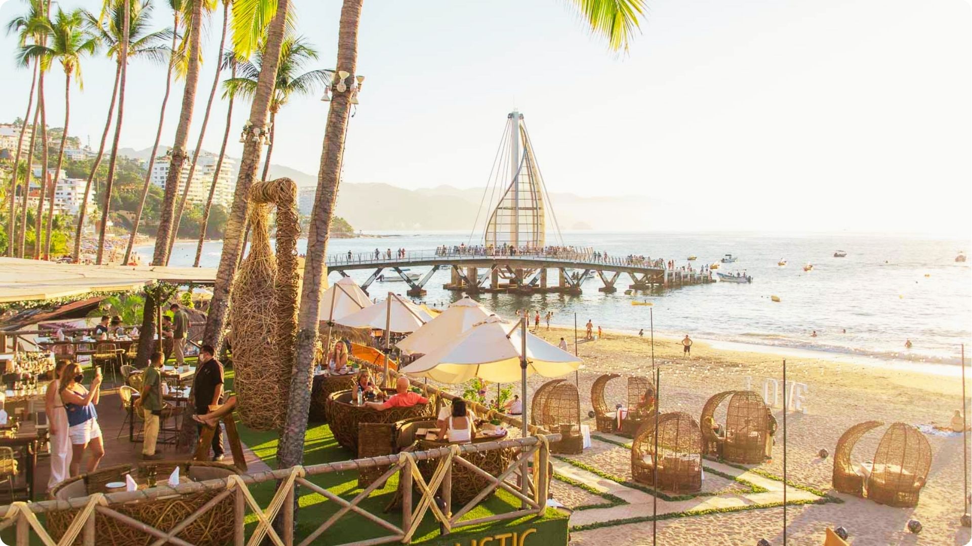 Dine at beachfront clubs on Playa de los Muertos with sunset views of the sail-shaped pier.